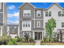 Charming two-story townhome with manicured lawn and walkway leading to covered front porch at 1729 Starlit Sky Ln, Cary, NC 27519