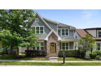 Charming two-story home features a manicured lawn, brick accents, and a welcoming yellow front door at 1962 Briar Chapel Pkwy, Chapel Hill, NC 27516