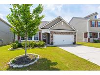 Charming home with a stone accent facade, well-manicured lawn, and a two-car garage at 202 E Painted Way, Clayton, NC 27527