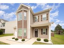 Inviting two-story home with mixed siding, covered porch, manicured front yard, and professional landscaping at 2309 King Malcolm Ln, Zebulon, NC 27597