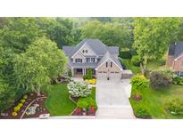 Beautiful home with lush landscaping, mature trees, and an inviting driveway creating a picturesque setting at 3024 Weston Ct, Burlington, NC 27215