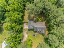 Aerial view of a charming house with lush green trees surrounding the property at 3304 Black Stallion Ct, Zebulon, NC 27597
