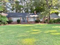 Charming brick home with a well-manicured lawn and mature trees offers great curb appeal at 3604 Woodlawn Rd, Rocky Mount, NC 27804