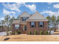 Charming two-story home with brick and siding exterior, manicured lawn, and inviting entrance at 40 Ironwood Blvd, Youngsville, NC 27596