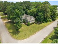 An aerial view reveals a home nestled within a lush, maturely wooded lot on a desirable corner at 44 Supreme Dr, Lillington, NC 27546