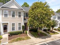 Charming townhome featuring a well-maintained lawn, tidy landscaping, and inviting front entrance at 5717 Corbon Crest Ln, Raleigh, NC 27612