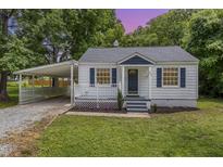 Charming one-story home featuring blue shutters, a covered porch, and a convenient carport at 603 S Third St, Mebane, NC 27302