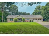 Charming brick home features an attached two-car garage and well-maintained lawn at 6305 Holly Ridge Rd, Rougemont, NC 27572
