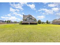 Charming two-story home with beautiful landscaping, a spacious yard, and classic architectural details at 656 Atkins Rd, Fuquay Varina, NC 27526