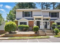 Inviting townhouse with brick facade, manicured greenery, and steps leading to a covered entrance at 7708 Falcon Rest Cir, Raleigh, NC 27615