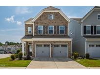Charming brick home featuring a two-car garage, well-maintained lawn, and classic architectural details at 1018 Excite Ave, Morrisville, NC 27560