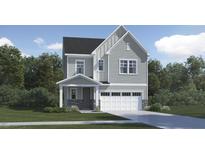 Charming two-story home showcasing a gray exterior, a front porch, an attached two-car garage, and a well-maintained lawn at 1240 Coral Cay Bnd, Wake Forest, NC 27587