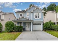 Charming two-story home with light blue siding, white trim, and a well-maintained front yard at 128 Palmdale Ct, Holly Springs, NC 27540