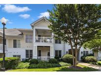 Charming two-story condo featuring double balconies, landscaped grounds, and a welcoming exterior paint scheme at 1310 Durlain Dv # 103, Raleigh, NC 27614