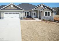 Charming single-Gathering home featuring stone accents, a two-car garage, and a well-manicured lawn at 148 Merrifield Ln # 128, Garner, NC 27529