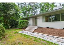 Charming single-story home with white brick, green trim, and a well-manicured front yard landscape at 1606 Sycamore St, Durham, NC 27707