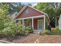 Charming red bungalow with a cozy front porch and mature landscaping at 1916 Hart St, Durham, NC 27703