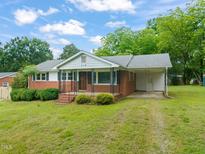 Charming brick home with a well-manicured front yard and covered porch at 218 Forestville Rd, Wake Forest, NC 27587