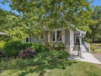 Charming home featuring mature trees, lush landscaping, and a convenient ramp to the front entrance at 224 Kirkwood Dr, Chapel Hill, NC 27514