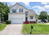 Charming two-story home with a manicured lawn, attached garage, and inviting front porch at 2241 Spruce Shadows Ln, Raleigh, NC 27614