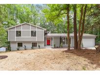 Charming split-level home with gray siding, brick accents, and a vibrant red front door at 2905 Scuppernong Ln, Durham, NC 27703