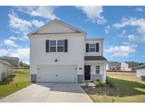 Charming two-story home with white siding, attached garage, and landscaped front yard on a sunny day at 316 Mimosa Ct, Sanford, NC 27332