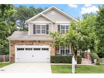 Charming two-story home features a stone facade, well-manicured lawn, and a two-car garage at 3217 Ranbir Dr, Durham, NC 27713