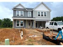 Two-story house with gray siding and white trim during the construction phase showing the front and the bare ground at 35 Windflower Court Ct # Homesite 9, Clayton, NC 27520