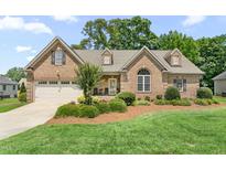 Charming single-Gathering home featuring a brick facade, two car garage, and manicured landscaping at 412 Whitt Ave, Burlington, NC 27215