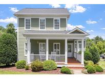 Charming two-story home featuring a welcoming front porch with classic white columns and manicured landscaping at 500 Weaver Mine Trl, Chapel Hill, NC 27517