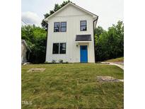 Charming two-story home features a bright blue front door, black trimmed windows, and well-manicured lawn at 608 A E Umstead, Durham, NC 27701