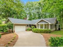 Charming single-story home boasts a well-manicured lawn and a winding driveway leading to a two-car garage at 6605 Huntingridge Rd, Chapel Hill, NC 27517