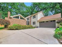 Charming two-story home featuring a brick accent wall, a large driveway, and an attached two-car garage at 6701 Winding Trail Trl, Raleigh, NC 27612