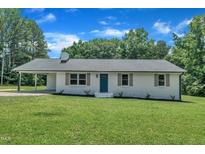 Charming single-story home featuring a painted brick facade, well-manicured lawn and a covered side entry at 802 Creech Church Rd, Kenly, NC 27542