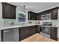 Modern kitchen featuring dark cabinets, stainless steel appliances, and light countertops, creating an elegant and functional space at 802 Creech Church Rd, Kenly, NC 27542
