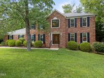 Charming two-story brick home with manicured lawn and mature landscaping at 116 Lost Tree Ln, Cary, NC 27513