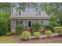 Charming home featuring dormer windows, a brick walkway, and lush landscaping at 1302 Valley Run Dr, Durham, NC 27707