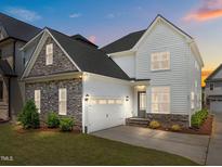 Two story home boasts stone accents, attached garage, and manicured lawn at 132 Cotten Dr, Morrisville, NC 27560