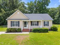 Charming single-story home with a well-manicured lawn, complemented by mature trees and an inviting front porch at 161 Bridgewater Dr, Erwin, NC 28339