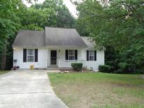 Charming single-story home featuring white siding, black shutters, a well-manicured lawn, and a concrete driveway at 221 Hickory Glen Ln, Durham, NC 27703