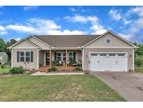 Charming single-story home with a welcoming front porch and well-maintained landscaping under a beautiful blue sky at 272 W Gennessee Dr, Zebulon, NC 27597