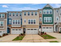 Charming townhomes showcase a mix of neutral siding and stone accents, creating an inviting street view at 2735 Hunter Woods Dr # 571, Apex, NC 27502