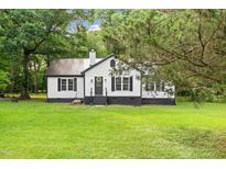 Charming one story home featuring a metal roof, beautiful lawn, and mature shade trees at 2809 Titleist Dr, Hillsborough, NC 27278