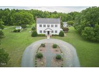 A stunning colonial style home with a sprawling front yard, and a circular driveway at 3679 Oak Lawn Farm Rd, Oxford, NC 27565