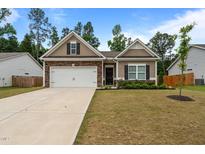 Charming single-story home featuring stone accents, a two-car garage, and a well-manicured front lawn at 5081 Pioneer Dr, Sanford, NC 27330
