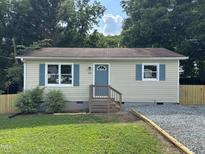 Charming single story home with beige siding, blue shutters and entry door, and a well kept yard at 510 North St, Graham, NC 27253