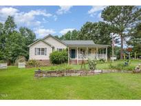 Charming single Gathering home featuring well maintained yard, landscaping and inviting front porch at 559 Blue Pond Rd, Clayton, NC 27520