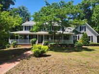 Charming two-story home with a welcoming front porch and mature landscaping in a lush yard at 5760 Hesters Store Rd, Hurdle Mills, NC 27541