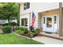 Inviting home entrance with an American flag and a well-manicured garden and decorative plants at 6021 Dixon Dr, Raleigh, NC 27609