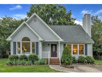 Charming single-story home with tidy landscaping, blue siding and a brick walkway leading to the front door at 8 Great Oak Ct, Durham, NC 27713